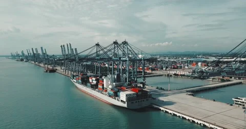 Logistics container cargo ship with working crane bridge in Port Klang Stock Footage 133867161