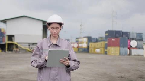 Logistics inspector wearing a hard hat performs a site audit with a tablet Stock Footage 334946637