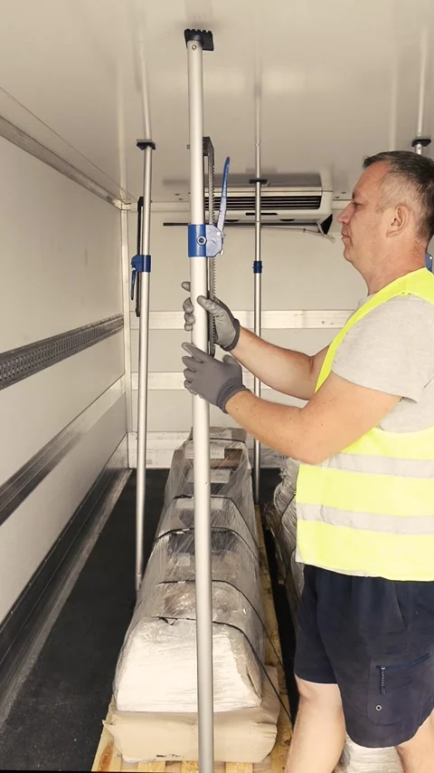 Logistics man removing a safety cargo securing bar inside a truck trailer Stock Footage 341825210