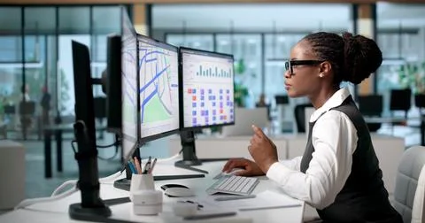 Logistics Manager Uses Computer At Workplace To Review Shipment Schedules Car Stock Photos
