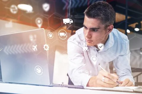Logistics professional analyzes data and makes notes at work in an office Stock Photos