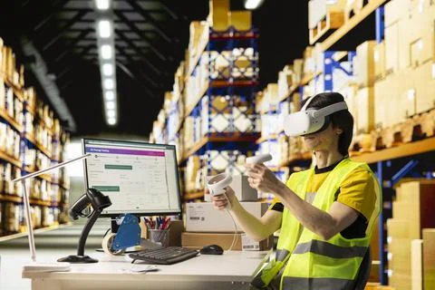 Logistics staff uses virtual reality glasses and AI software in distribution hub Stock Photos