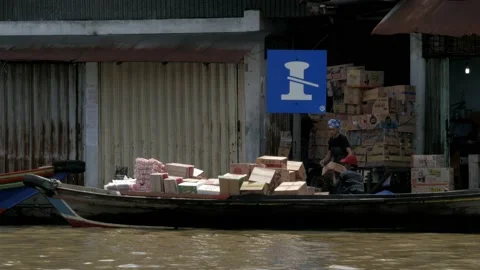 Logistics supply loaded by local workers into a small wooden cargo boat Stock Footage 132592281