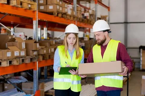 Logistics team walking through warehouse checking shipment details Foto stock