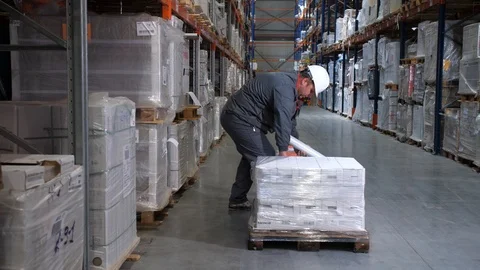 Logistics warehouse. The worker packs pallets with products. 4K Slow Mo Video stock 111764963