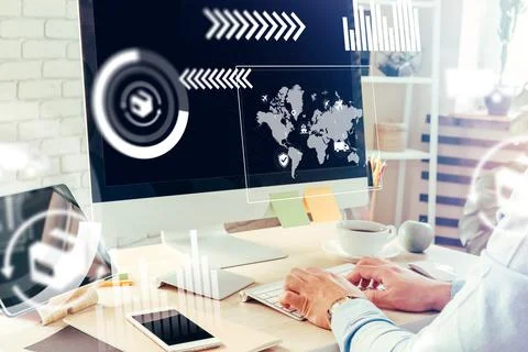 Logistics work at a desk with computer displaying global data and charts during 스톡 사진