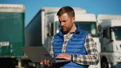 Logistics worker managing fleet operations on laptop Stock-Footage 299757432