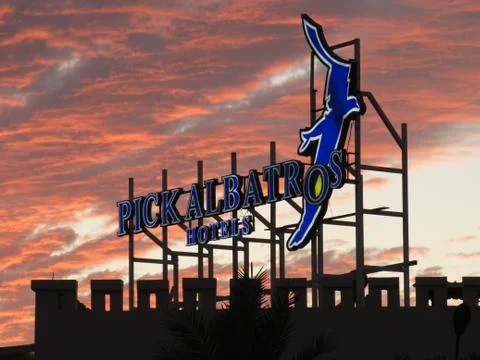 The logo of the Pick Albatros hotel in front of a dramatic sunset Stock Photos