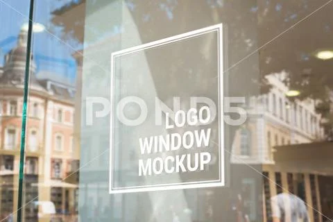 Logo, sign mockup on store glass window. City buildings in background PSD Template