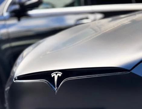 The logo Tesla on the hood black matte car. Stock Photos