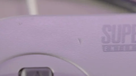 Logo on Vintage Super Nintendo Controller in Purple Light SLIDE RIGHT Stock Footage 102814082