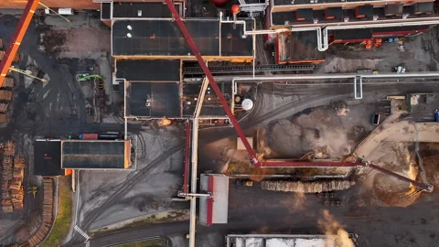 Logs are being processed at a lumber mill paper plant at sunset Stock Footage 297054879