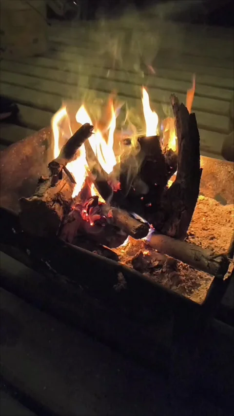 A logs burning inside a rustic fire pit 動画素材 345082125