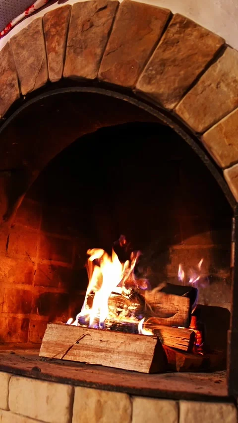 Logs burning in stone arch fireplace with dancing yellow flames and sparks .. Stock Footage 337481963