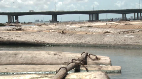 Logs floating in river, big traffic bridge behind Stock Footage 38387436