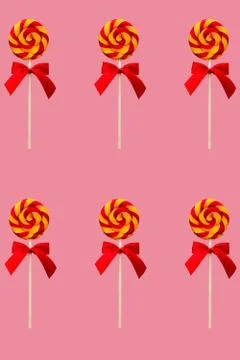 Lollipop candy, round shape and colorful curls. Holiday sweets for kids on pink  Stock Photos