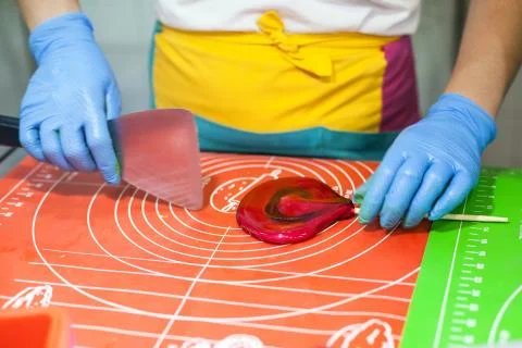 Lollipop preparation process, master makes caramel. Heart lollipop. Stock Photos