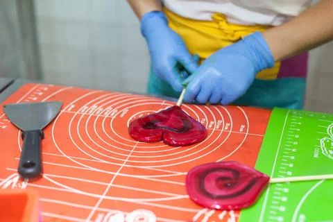 Lollipop preparation process, master makes caramel. Heart lollipop. Stock Photos