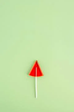A Lollipop in the shape of a triangle on a green background Stock Photos