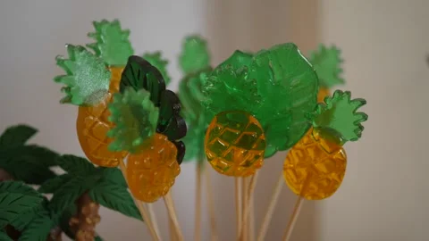 Lollipops candy on a stick in the form of pineapple are on the candy bar. Stock Footage 217397146