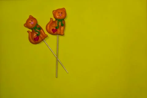 Lollipops in the form of cat on a yellow background Stock Photos