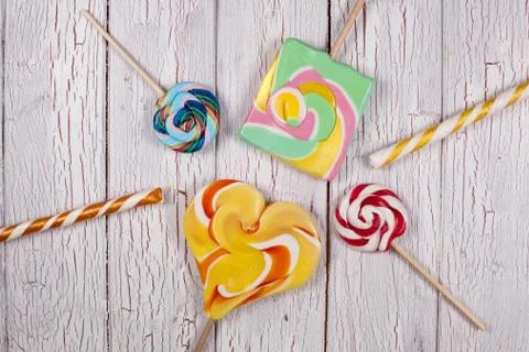 Lollypops making a shape of a sun on a white wooden background Stock Photos