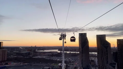 London Cable Car Gondolas Over Thames River and City Skyline at Sunset Stock Footage 328587945