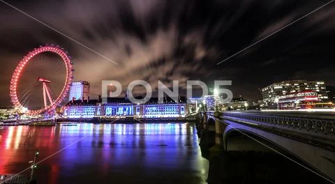 London eye and river at night long exposure with red bus on bridge Stock Photos