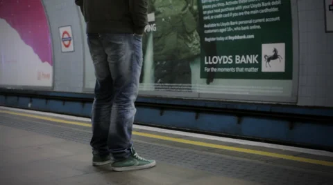 LONDON:  Man with a jacket stands on a platform and waits for a train Vídeo Stock 34557533
