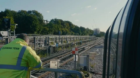 London underground working standing outside tube train on platform on sunny day Stock Footage 88955886