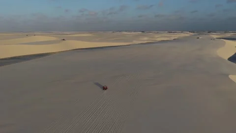 Lone ATV Crossing Broad Dunes Beside a Lagoon in Lençóis Maranhenses Video stock 342446327