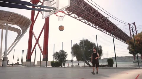 A lone basketball player throws a ball in the street with an amazing view Stock Footage 248727958