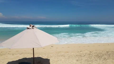 Lone beach umbrella on a sandy beach against the waves of the ocean. Stock Footage 287244796