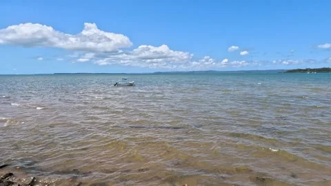 Lone Boat Floating in a Large Bay Stock Footage 257642802