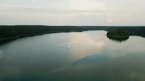 A lone boat floats on the smooth surface of the lake Video stock 248859829