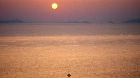 Lone boat in front of sunset over caldera in Santorini, Greece Stock Footage 254302393