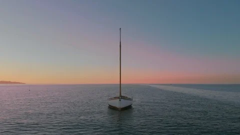 Lone boat moored during magic hour gently bobs on the water - DJI 0425 Stock Footage 105145962
