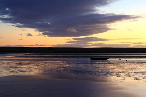Lone boat at sunset Stock Photos