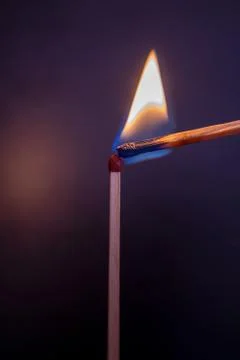 Lone burning match with the flame in the upper left side of the frame isolate Stock Photos