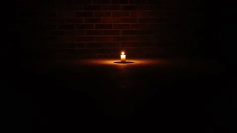 Lone Candle Against Brick Wall Surrounded By Darkness Push In Stock Footage 233456830