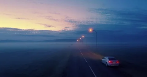 Lone car remote highway road at dusk aerial perspective foggy landscape Stock Footage 76182450