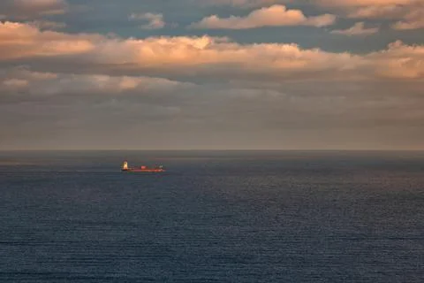 Lone cargo ship at dusk Stock Photos