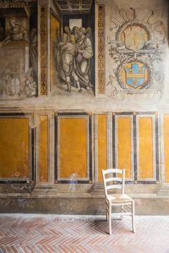 A lone chair sitting in diffused light coming from the right with medieval fr Photos