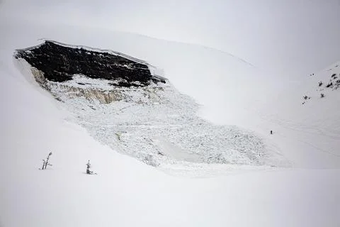 A lone figure challenges the aftermath of an avalanche, skiing through the .. Stock Photos