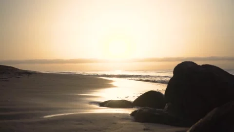 Lone figure is walking on a beach during sunrise Stock Footage 293157964