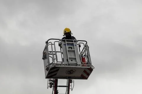 Lone firefighter looking down from a high access ladder in Coruna Spain Stock Photos
