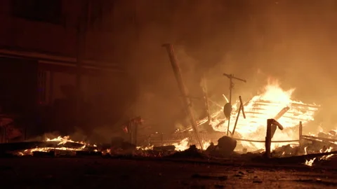 Lone firefighter watching smoldering falla remains during Las Fallas La Crema Video stock 334231450