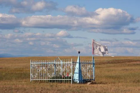 Lone grave adorned with soviet red star in the middle of steppe in olkhon isl Stock Photos