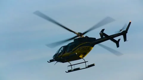 Lone Helicopter Flies Away from Camera Toward City- Slow Motion Video stock 57169628