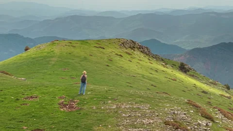 Lone Hiker on Sunlit Grassy Ridge in the Pyrenees Stock Footage 345265437